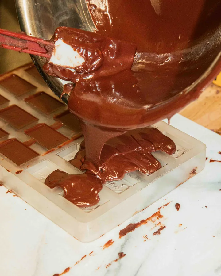 Pouring rich, melted chocolate into a mold during a Bean-to-Bar Chocolate Class in New York City.