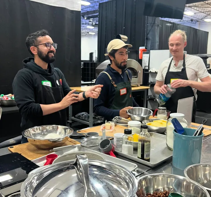 Three participants enjoy a Cookie Dough Workshop in San Carlos, surrounded by baking ingredients and tools.
