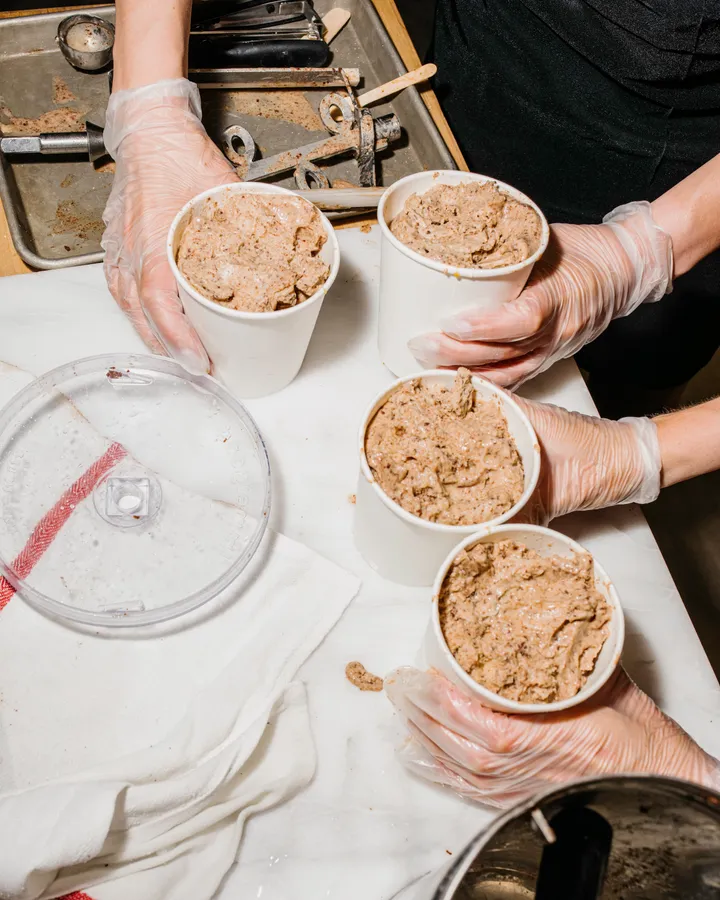 Participants hold four cups of freshly made ice cream during a team-building activity in New York City.