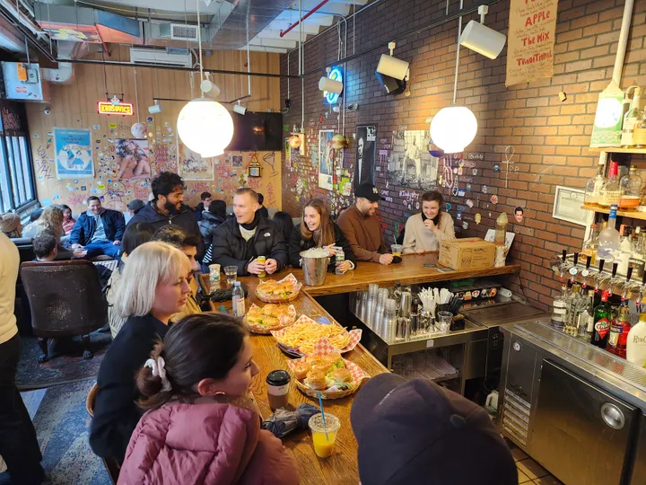 A lively bar scene in Industry City, Brooklyn, with guests enjoying food and drinks during a team building event.