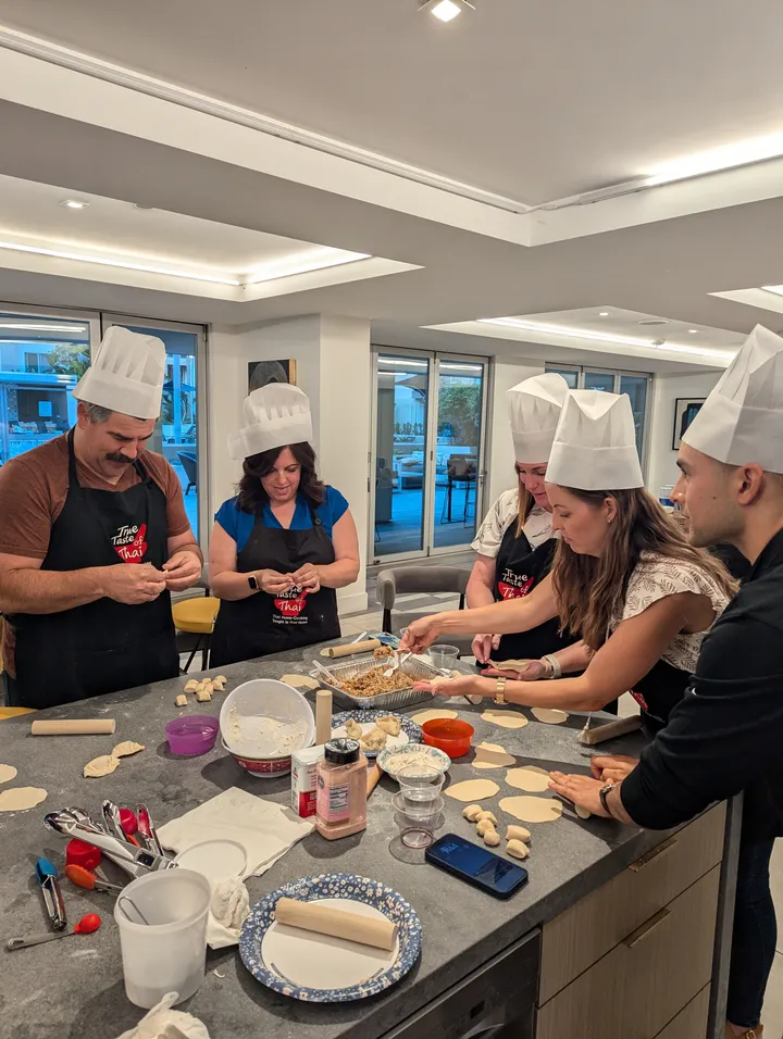 Group participating in a Japanese Gyoza Dumpling Class, making dumplings in an interactive kitchen setting.