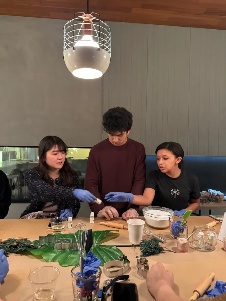 Participants engage in a Natural Diffuser Crafting Class in NYC, mixing ingredients and sharing tools.