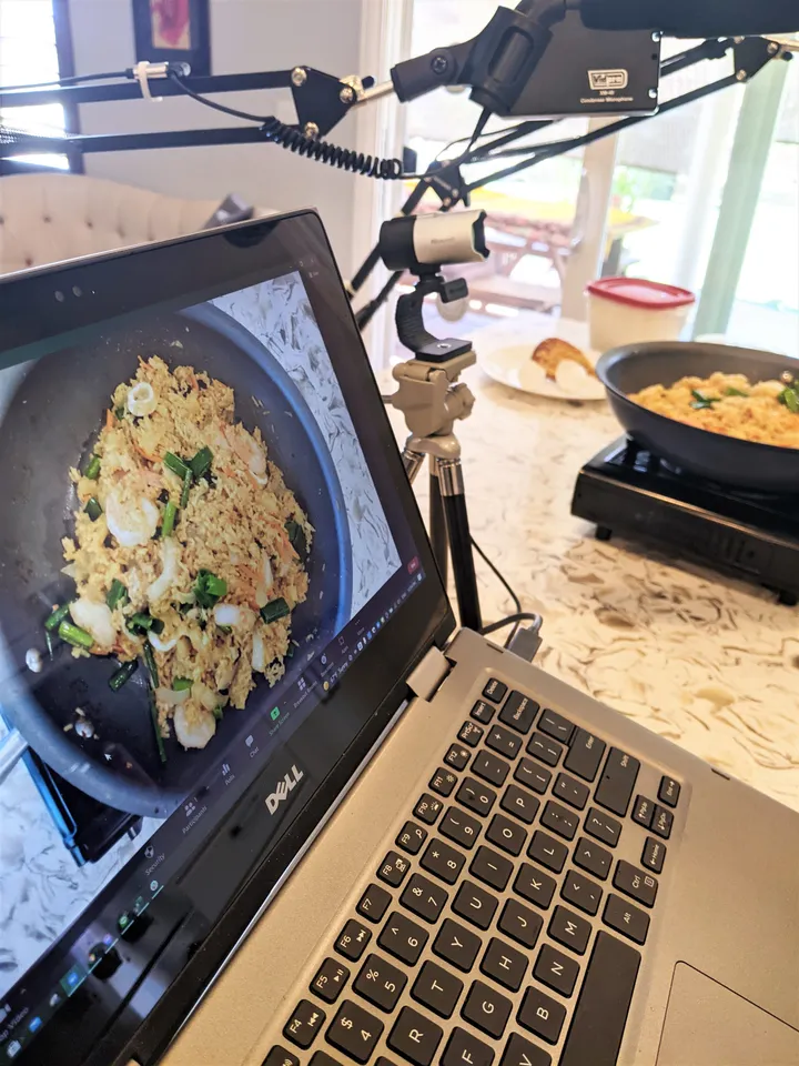 Laptop showing a video call of a Pineapple Fried Rice cooking class, with a pan of fried rice in view.