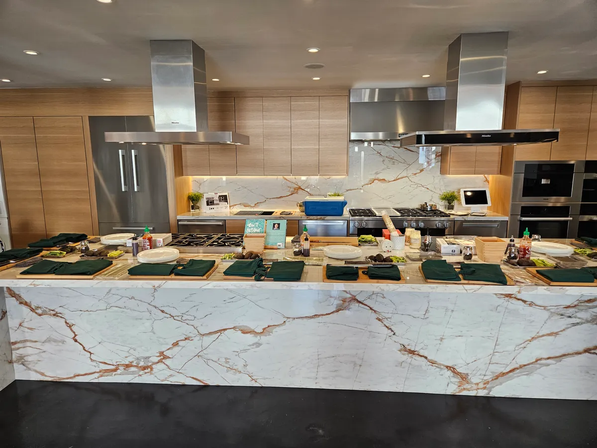 A modern kitchen set for a sushi-making workshop, with ingredients and tools neatly arranged on a marble countertop.