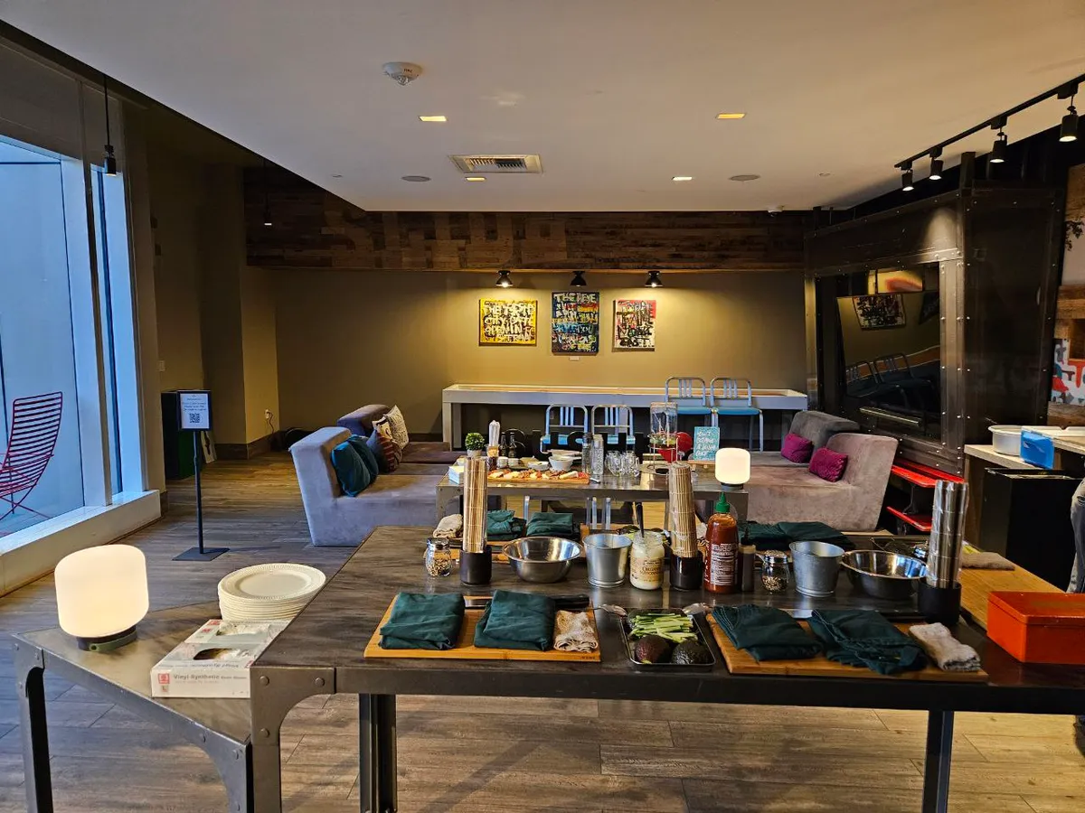 A spacious room set up for a sushi-making workshop, featuring tables with ingredients and cozy seating.