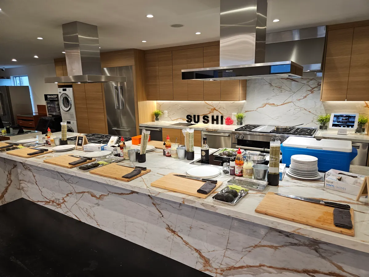 Sleek kitchen setup for a sushi-making workshop, featuring ingredients and tools on a marble countertop.