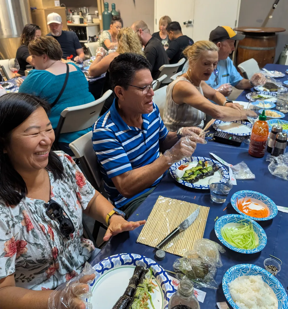 Participants enjoy a sushi rolling class in San Diego, preparing sushi with fresh ingredients and laughter.