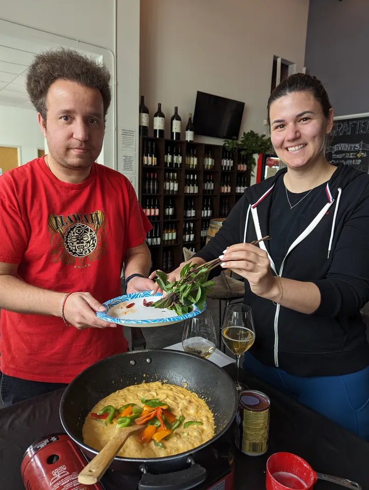 Participants in a Thai red curry class in San Diego prepare ingredients beside a cooking pot.