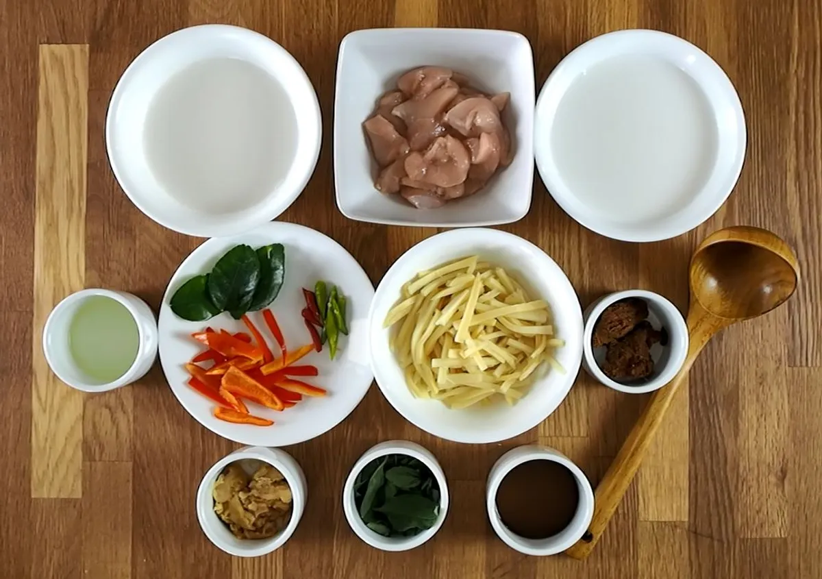 Ingredients for a Thai red curry class, including chicken, vegetables, spices, and coconut milk arranged in bowls.