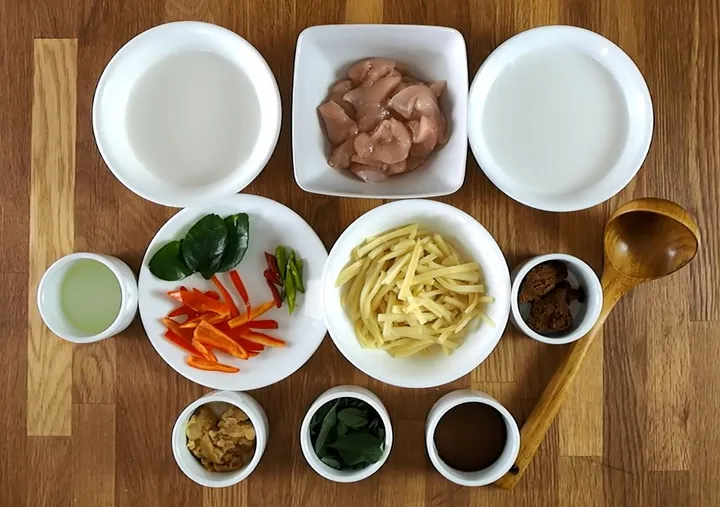 Ingredients for a Thai red curry class, including chicken, vegetables, spices, and coconut milk arranged in bowls.