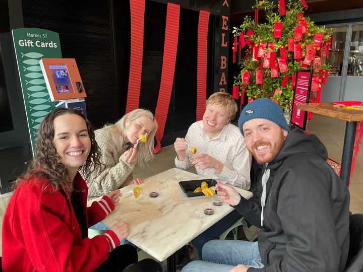 Four friends enjoy food together at a table during a VIP Seated Food Tour in New York City.